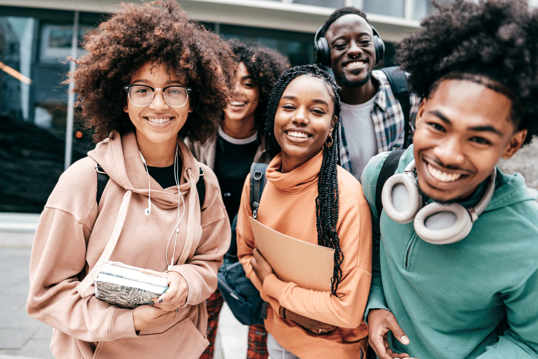 Group of 4 college students walking outside together and laughing